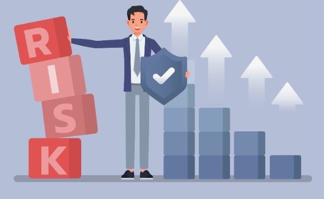 Businessperson holding a shield with a checkmark while red blocks spell 'RISK' on the left and a rising bar chart with upward arrows on the right.